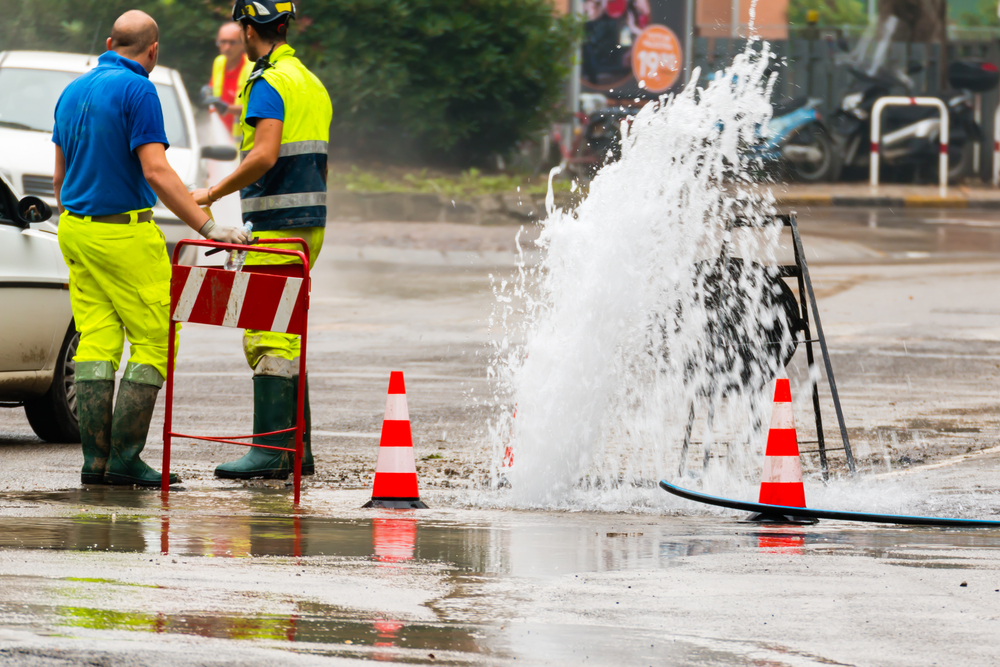 Road,spurt,water,beside,traffic,cones